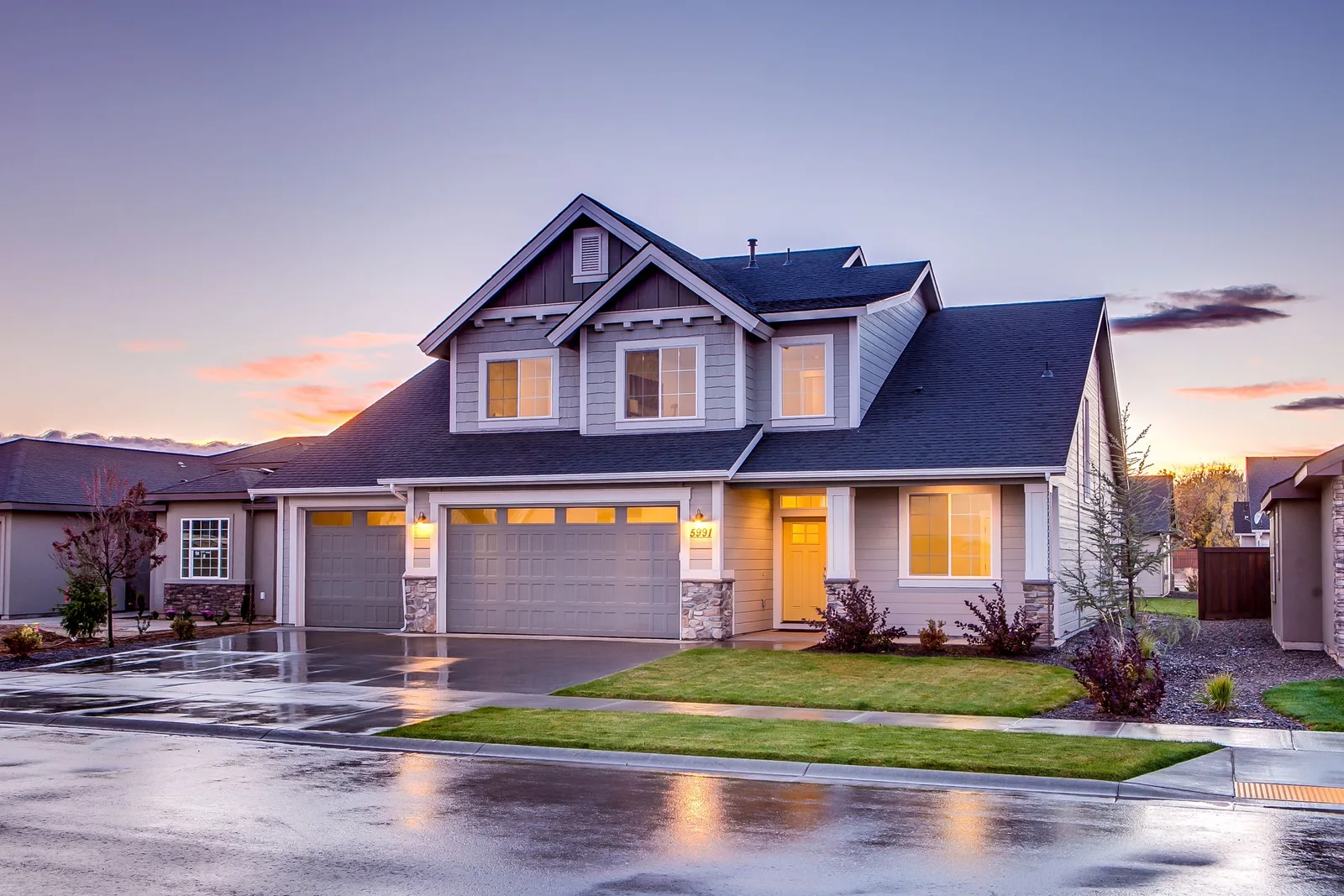 Twilight exterior, warm interior glow, aerial three-quarter view