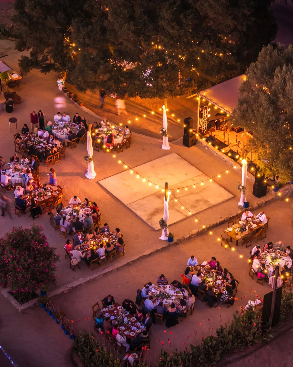 Open-air first dance at dusk, string lights from above